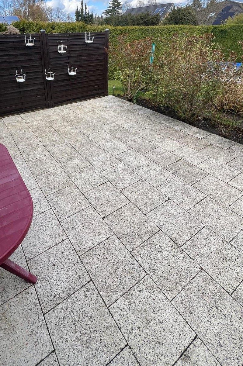 Terrasse nach der Hochdruckreinigung: helle, saubere Steinfläche im Sonnenlicht